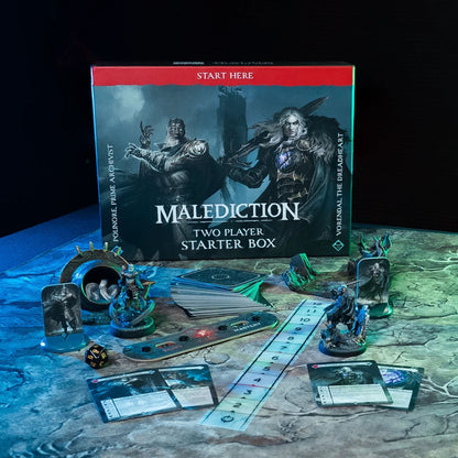 Malediction Two Player Starter Box – pudełko gry na tle mapy z rozłożoną zawartością: standees Polinore i Vorendal, talia kart, linijka, pasek Echo/Mastery, kość D20 i karty jednostek na ciemnym stole