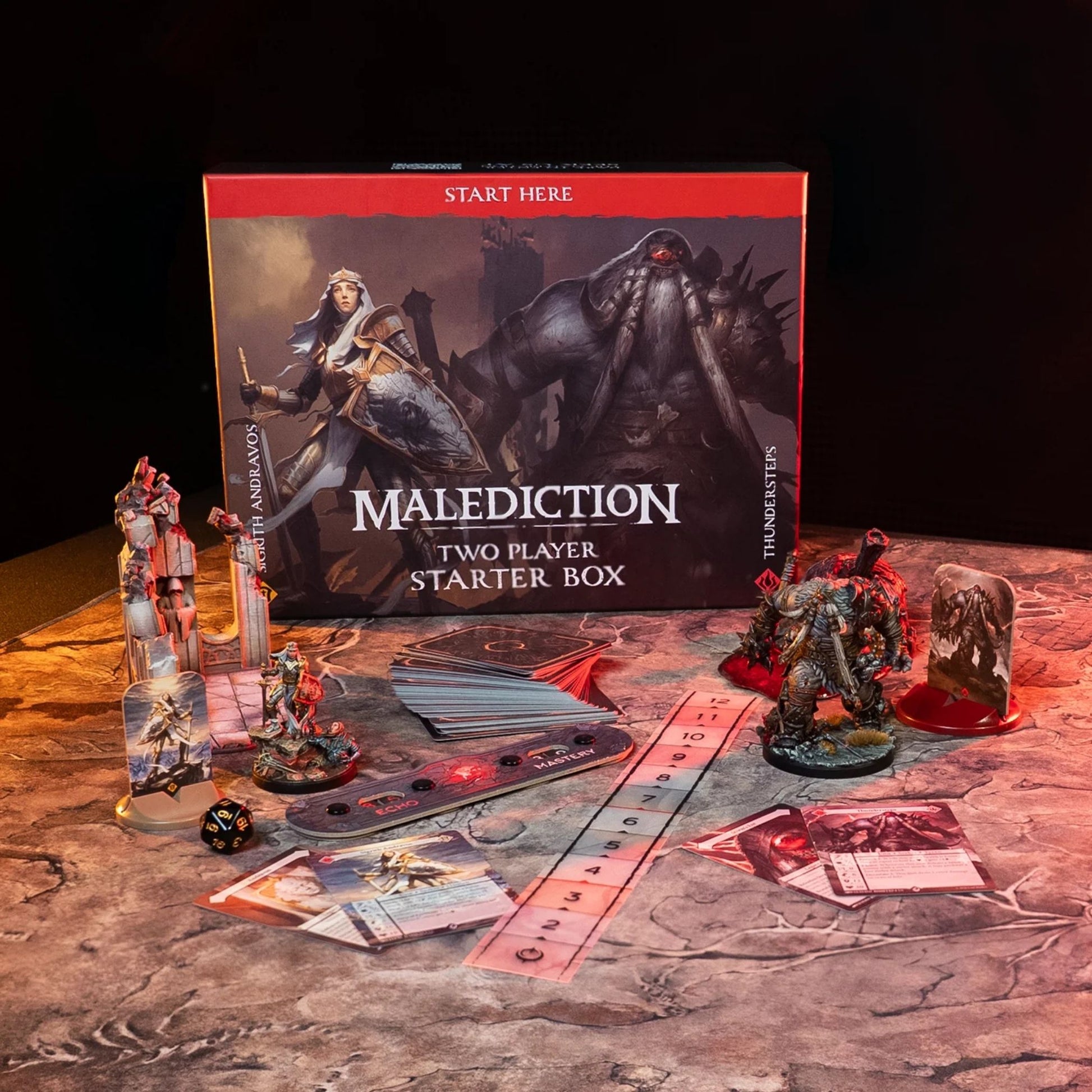 Malediction Two Player Starter Box Sigrith vs Thundersteps – pudełko gry z rozłożoną zawartością: standees Sigrith i Thundersteps, talia kart, linijka, pasek Echo/Mastery, kość D20 i karty jednostek na ciemnym kamiennym stole