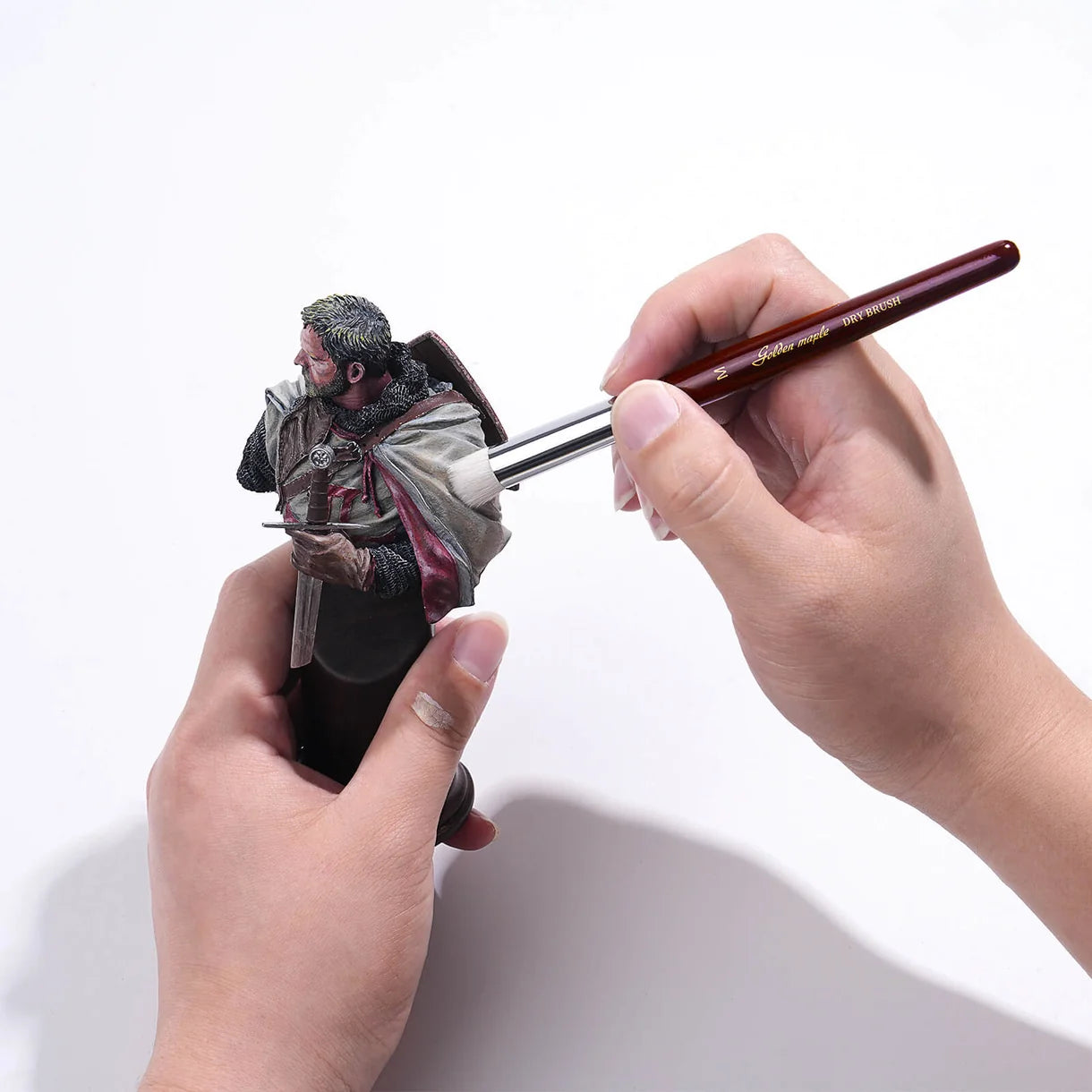 Dry brushing figurki rycerza pędzlem Golden Maple Dry Brush – technika suchego pędzlowania na modelu fantasy, widoczny drewniany uchwyt z napisem Golden Maple
