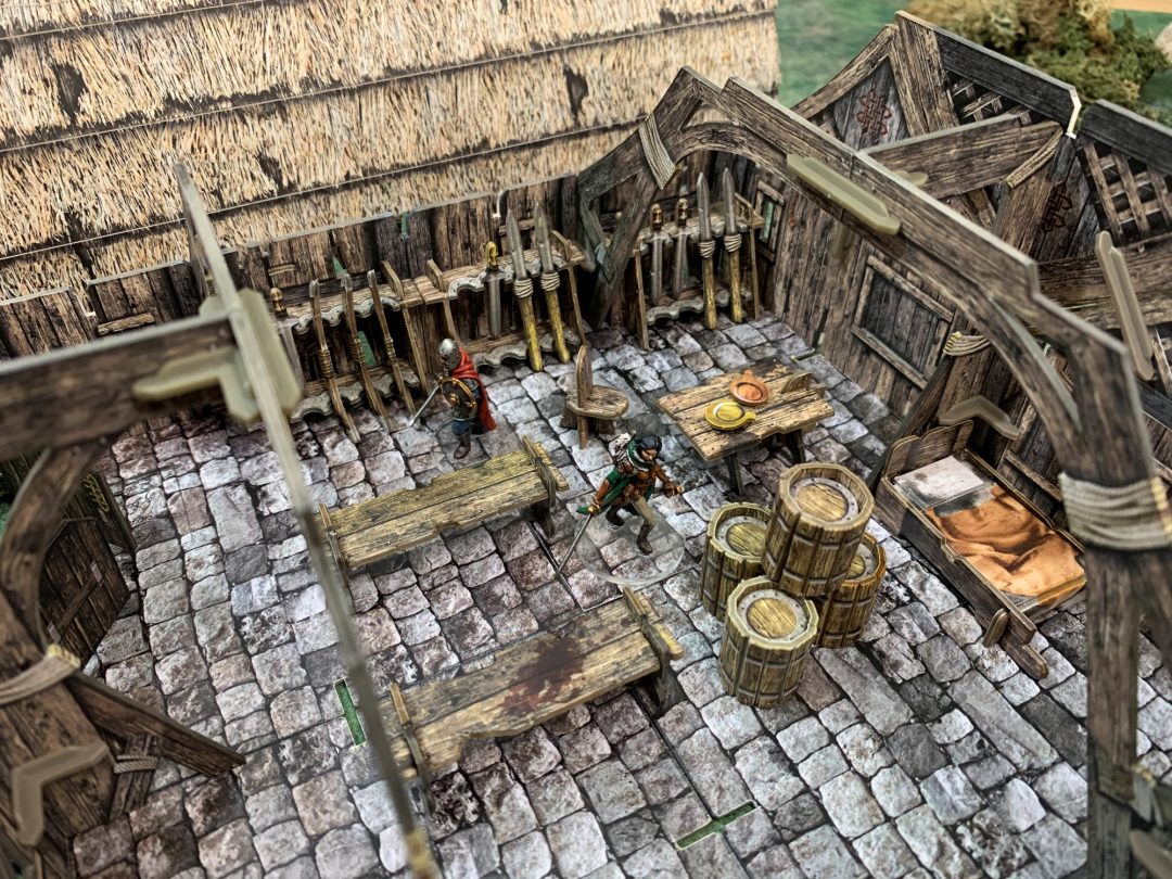 Mead Hall BSTFWE018 28-35mm Battle Systems - wnętrze sali miodowej ławy stoły beczki stojaki na broń figurki walczące widok z góry
