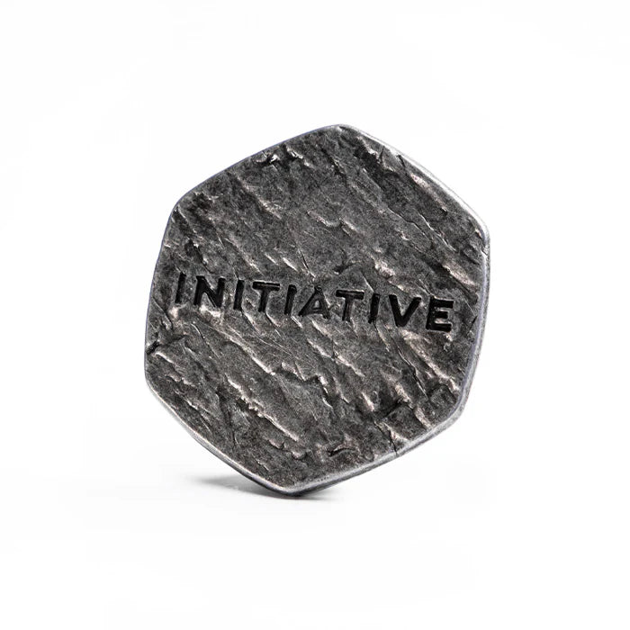 Malediction Metal Initiative Token – rewers: ośmiokątny metalowy żeton z wytłoczonym napisem INITIATIVE na kamiennej teksturze, postarzane srebrne wykończenie na białym tle