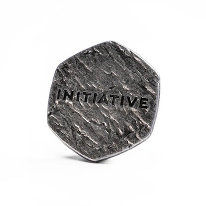 Malediction Metal Initiative Token – rewers: ośmiokątny metalowy żeton z wytłoczonym napisem INITIATIVE na kamiennej teksturze, postarzane srebrne wykończenie na białym tle