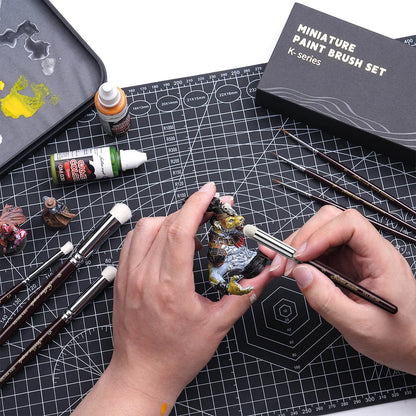 Dry brushing figurki smoka pędzlem Golden Maple Dry Brush – pędzle K-Series i pudełko Miniature Paint Brush Set na czarnej macie
