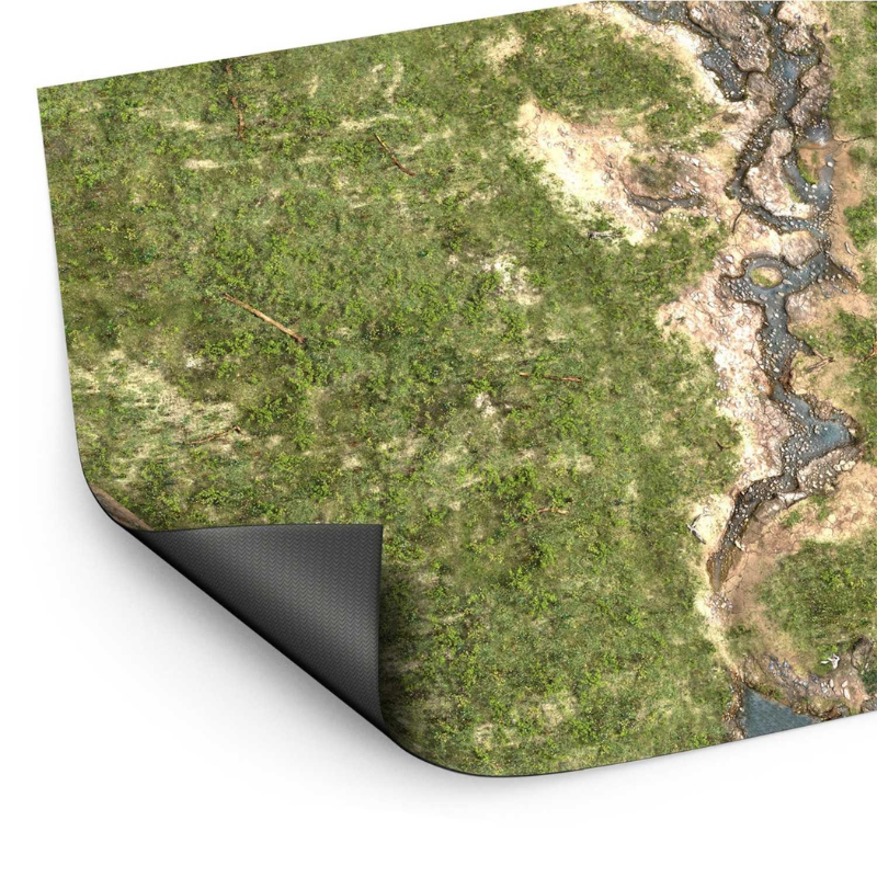 Wargame Mat Duskriver Meadows – mata neoprenowa 120x180cm zrolowana z widocznym spodem antypoślizgowym, zielona łąka z rzeką i kamieniami, białe tło