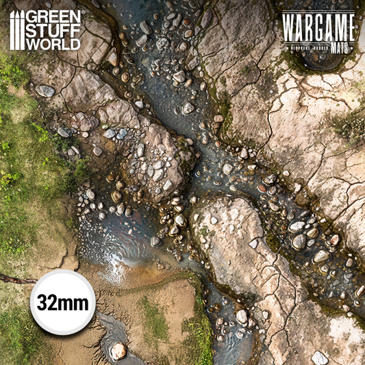 Green Stuff World Wargame Mat Duskriver Meadows XL 70x48" – zbliżenie na kamienistą rzekę z kamieniami i pękniętą ziemią, zielona trawa na brzegach, skala 32mm, logo GSW i Wargame Mats