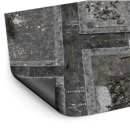 Wargame Mat Ground Zero District – mata neoprenowa 120x180cm zrolowana z widocznym spodem antypoślizgowym, miejska ruina z drogami i gruzem, białe tło