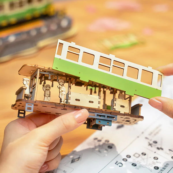 Tramwaj Sakura Journey Rolife TGS02 – gotowy model zielonego tramwaju z kwitnącą sakurą i semaforami, widok frontalny na białym tle