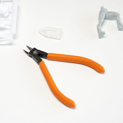 Redgrass Sprue Cutters – nożyczki do wyprasek z pomarańczowymi uchwytami na białym tle z figurką i wypraskę w tle
