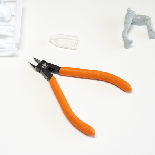 Redgrass Sprue Cutters – nożyczki do wyprasek z pomarańczowymi uchwytami na białym tle z figurką i wypraskę w tle

