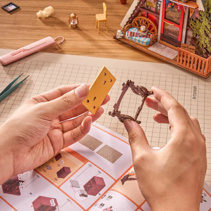 Górska Chata A-Frame Cabin Rolife DG181 – gotowy model nocny z otwartym dachem, miniaturowymi figurkami kota i słonia na trawie w świetle LED