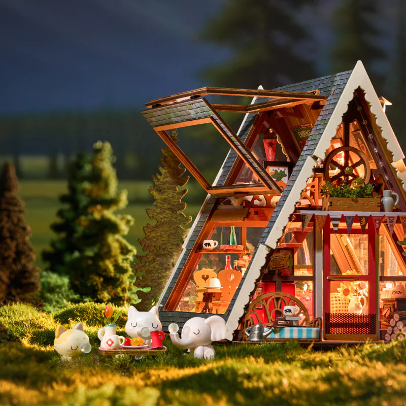 Górska Chata A-Frame Cabin Rolife DG181 – gotowy model na komodzie w salonie z żółtą lampą, widok z zamkniętym dachem
