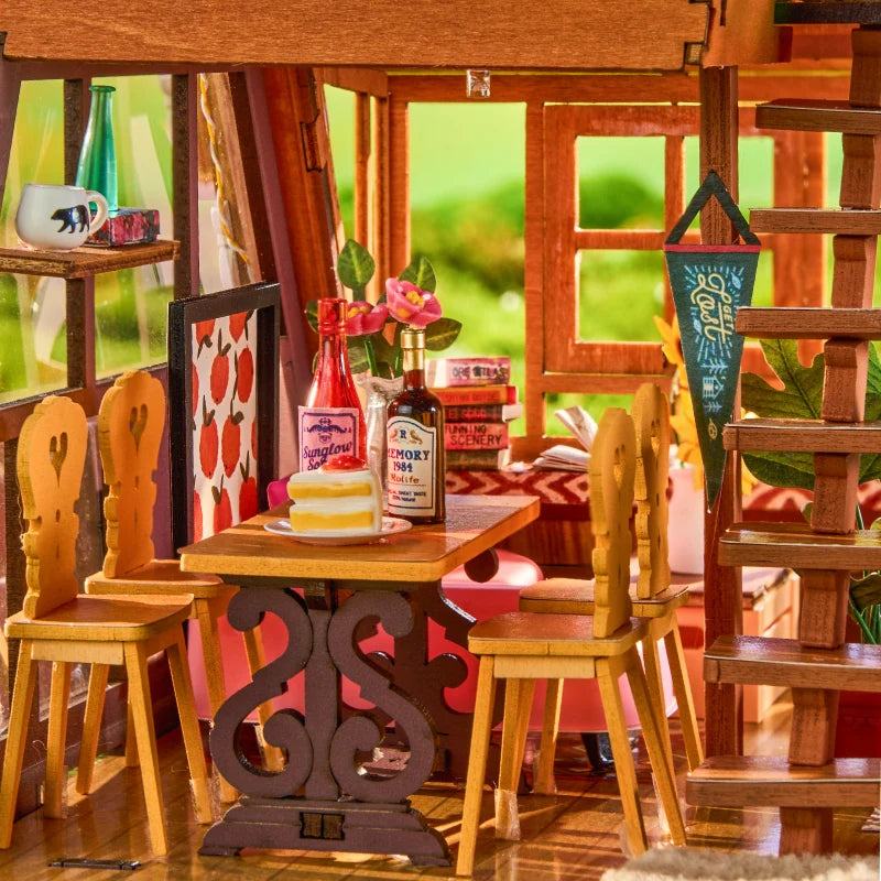 Górska Chata A-Frame Cabin Rolife DG181 – widok z boku na łące w lesie: ciepłe światło LED przez duże przeszklone ściany