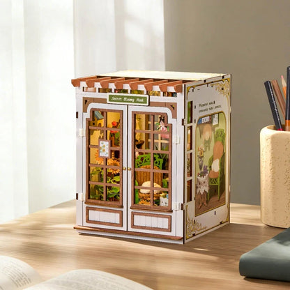 Tajemniczy Ogród Rolife TGE04 Secret Bloomy Nook – składanie zielonego fotela wiklinowego z elementów, ręce trzymające miniaturowe części