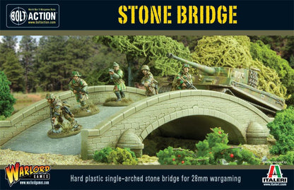 Stone Bridge WG-TER-40 - diorama Bolt Action 28mm z kamiennym mostem: pomalowany beżowy jednoarkowy kamienny most z ceglaną teksturą, balustrada z kamiennymi słupkami, 5 żołnierzy alianckich w mundurach khaki na moście i brzegu, zielony czołg Sherman M4 po prawej, niebieska rzeka pod mostem, gęsty las z drzew w tle, zielone krzewy i czerwone kwiaty na brzegu - STONE BRIDGE żółty napis na górze - Hard plastic single-arched stone bridge for 28mm wargaming - logo Warlord Games i Italeri - Plastic produced by I