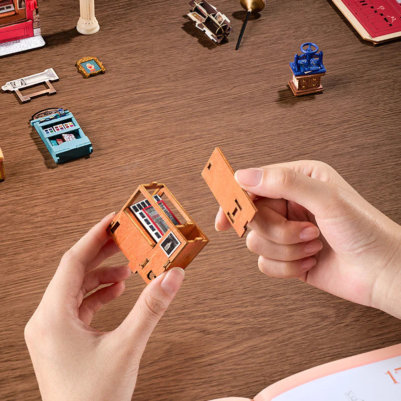 Sklep z Papeternią Wisdom Stationery Shop Rolife TGB19 – zbliżenie na miniaturowy regał z zestawami pasteli, pigmentów i szkicowników na trzech poziomach