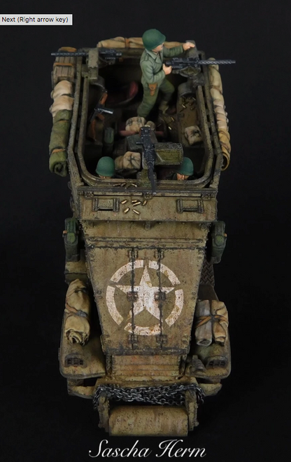 Rubicon Models 280083 M3A1 Scout Car – model 1/56 28mm widok z boku-tyłu: pustynny kamuflaż piaskowy z białą gwiazdą na tylnej płycie, strzelec przy M2 HMG, łańcuch holowniczy, koła terenowe, wyposażenie na burtach, czarne tło, Bolt Action