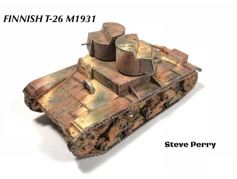 Rubicon Models 280070 T-26 – zmontowany i pomalowany model plastikowy 1/56 28mm: fiński T-26 M1931 w kamuflażu brązowo-rdzawym z efektem weatheringu i rdzy, wersja dwuwieżowa z dwiema okrągłymi wieżyczkami, gąsienice stalowe, widok z boku-przodu, białe tło, Bolt Action