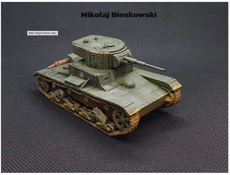 Rubicon Models 280070 T-26 – zmontowany i pomalowany model plastikowy 1/56 28mm: radziecki T-26 M1933 w oliwkowej zieleni z numerem 2 na wieży jednowieżowej, armata 45mm, gąsienice stalowe z weatheringiem, widok z boku-przodu, szare tło, Bolt Action