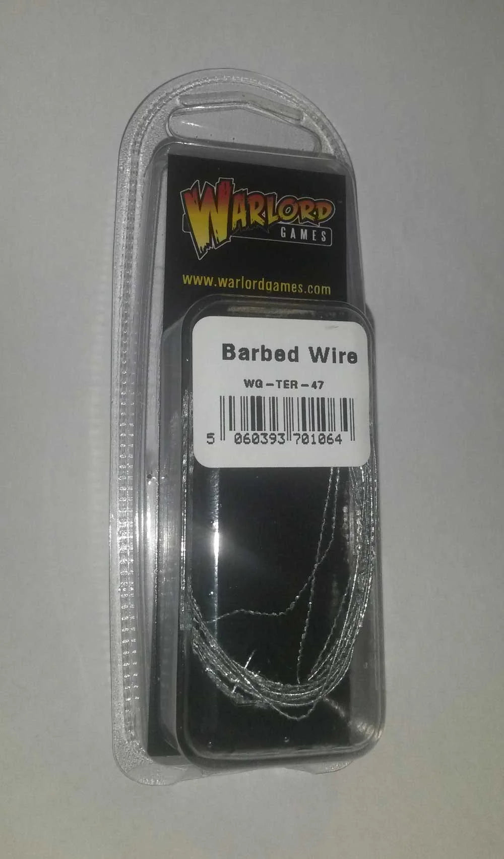 Warlord Games Barbed Wire WG-TER-47 – blister z drutem kolczastym do gier bitewnych: przezroczyste opakowanie z etykietą Warlord Games, 3 metry metalowego drutu kolczastego w skali 28mm Bolt Action