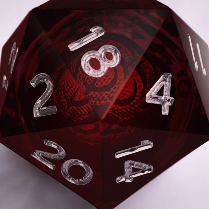 Malediction Special D20 – makro wnętrza kości D20: logo Malediction zatopione w czerwonym płynnym rdzeniu widoczne przez przezroczystą żywicę, srebrne cyfry na krawędziach