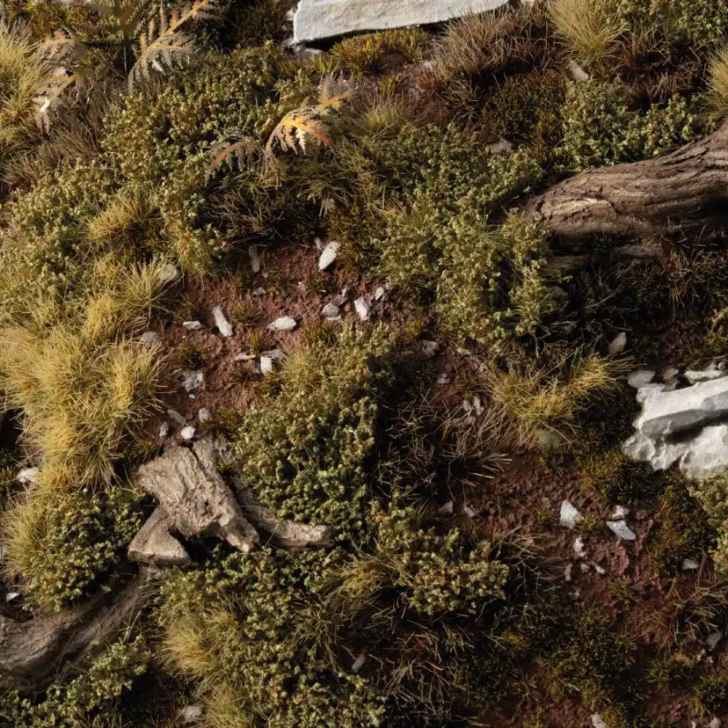 Dark Green Shrubs 6mm Gamers Grass - diorama górska z kamieniami, korzeniami i brunatną ziemią pokryta gęstymi ciemnozielonymi kępkami krzewów tworzącymi klimat nieprzeniknionego lasu
