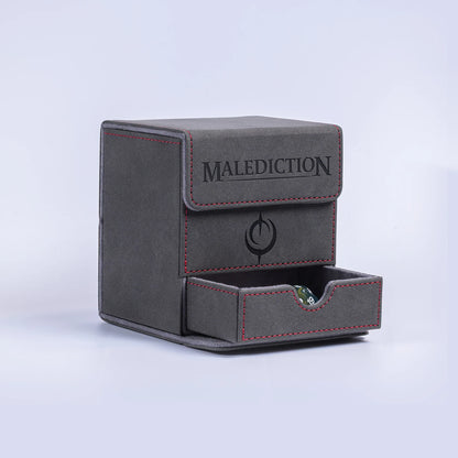 Malediction Premium Leather Deck Box – pudełko z wysuniętą dolną szufladą na kości z zieloną kością D20, napis MALEDICTION na wieczku, logo na froncie, czerwone szwy, szare tło