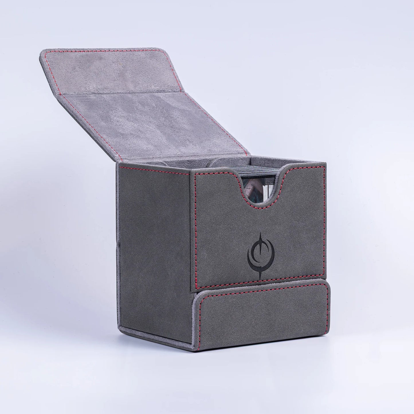 Malediction Premium Leather Deck Box – pudełko otwarte z uniesionym wieczkiem, widoczna górna komora na karty z wycięciem do wyjmowania i zamszowa wyścółka, logo Malediction na boku, szare tło
