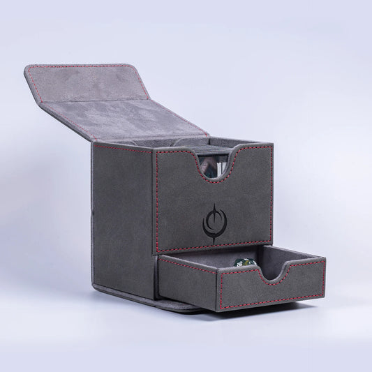 Malediction Premium Leather Deck Box – pudełko otwarte z uniesionym wieczkiem i wysuniętą dolną szufladą z zieloną kością D20, widoczna górna komora na karty z wycięciem, logo Malediction na boku, szare tło