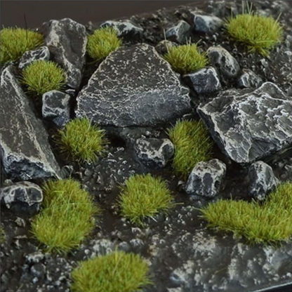Dry Green Tufts 2mm Small Gamers Grass - diorama skalna z czarnymi łupkowymi kamieniami pokryta drobnymi zielonymi kępkami trawy tworzącymi realistyczny, naturalny teren
