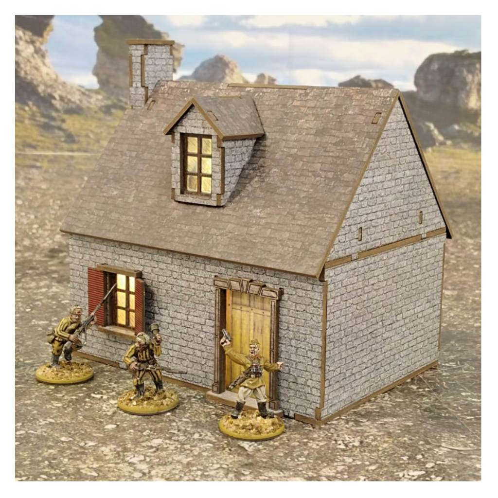 Europejski Dom Wiejski z Kamienną Elewacją 28mm – na stole z figurkami żołnierzy WWII na tle skał, SceneryWargames
