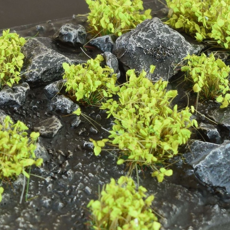 Green Shrub 6mm Wild Gamers Grass - diorama z czarnymi łupkowymi skałami i mokrą ziemią pokryta intensywnie zielonymi kępkami krzewów tworzącymi żywy, wiosenny klimat

