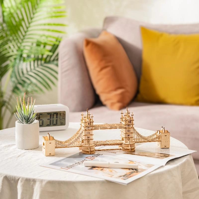 Drewniany puzzle 3D Tower Bridge Rolife RA003e – ukończony model na stoliku kawowym w salonie obok sukulenta, zegarka i magazynu
