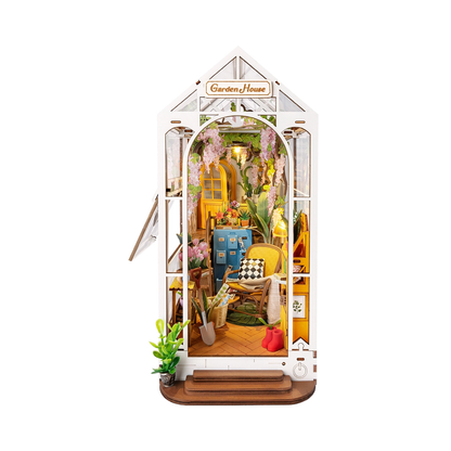 Dom Ogrodowy RDS010e - Book Nook DIY widok frontalny białe tło szyld Garden House glicynia wiklinowy fotel niebieska szafka łopata kalosze LED - Värvikas
