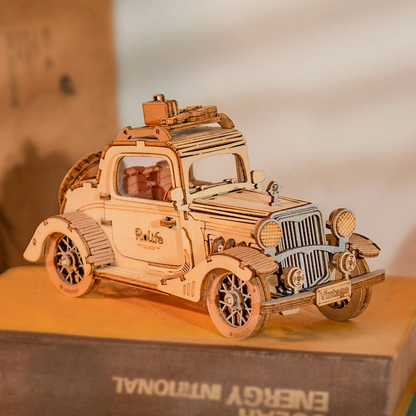 Mechaniczny drewniany model 3D Zabytkowy Samochód Rolife RA002e – ukończony model stojący na książce, widok z przodu i boku, bagażnik na dachu
