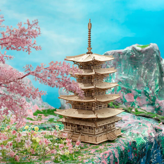 Drewniany puzzle 3D Pięciopiętrowa Pagoda Rolife RK013e – ukończony model na tle kwitnącej wiśni i błękitnych skał, japoński klimat wiosenny
