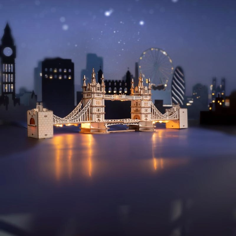 Drewniany puzzle 3D Tower Bridge Rolife RA003e – ukończony model na drewnianym stole z widokiem z boku, naturalna sklejka lipowa, długość 36 cm
