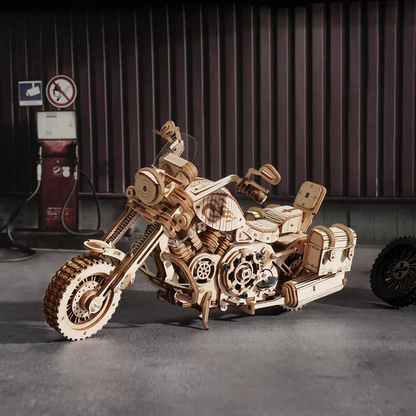 Mechaniczny drewniany model 3D Motocykl Cruiser Rolife RK026e – ukończony model na tle garażu z dystrybutorem paliwa, widok z prawej strony z widocznym silnikiem V-twin
