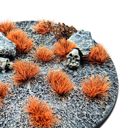 Martian Fluor Tufts 6mm Neo-Titan Orange Green Stuff World - zbliżenie na okrągłą podstawkę sci-fi z czaszką i kamieniami pokrytą fluorescencyjnymi pomarańczowymi kępkami Neo-Titan Orange
