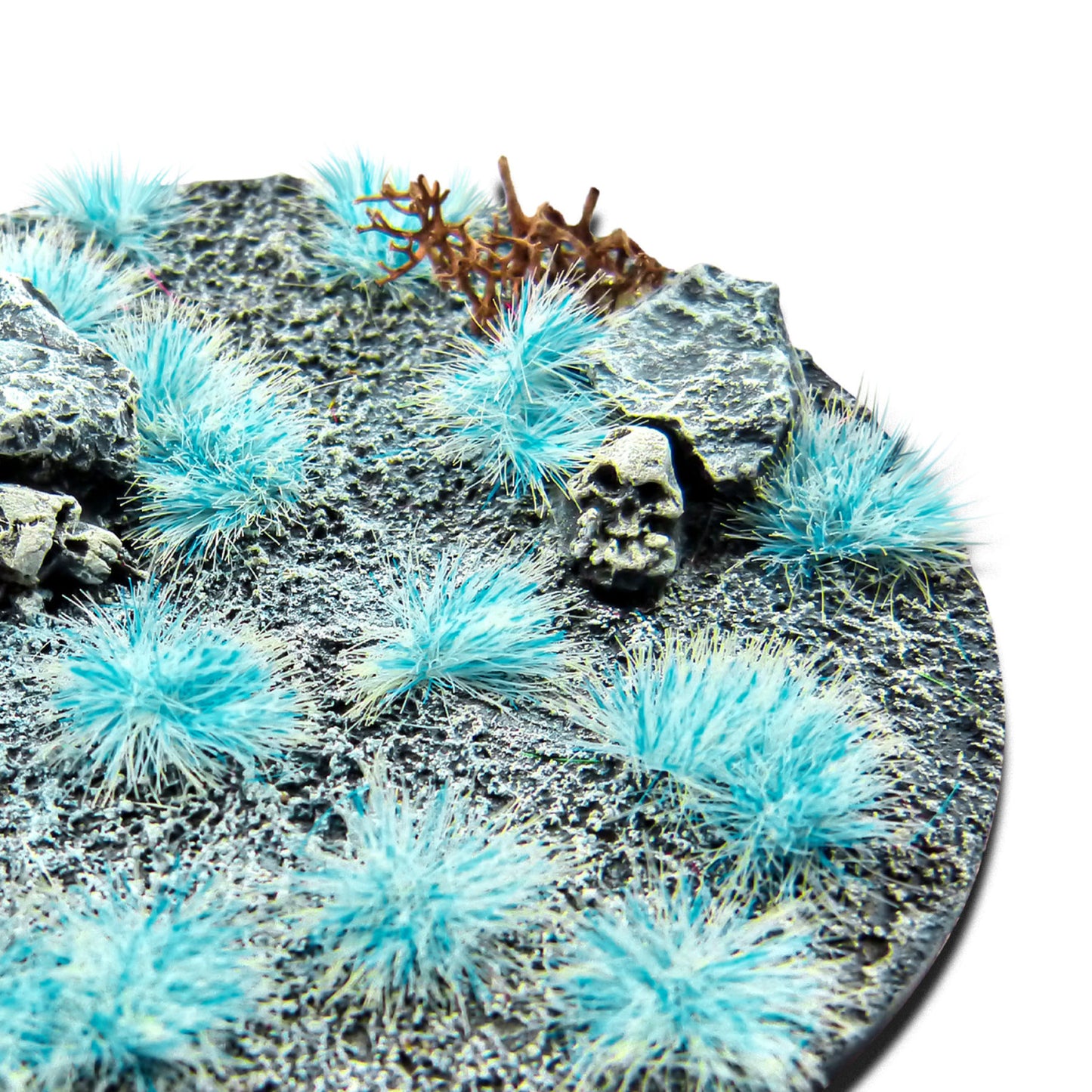 Martian Fluor Tufts 6mm Neon Yeti Blue Green Stuff World - zbliżenie na okrągłą podstawkę sci-fi z błękitnymi fluorescencyjnymi kępkami trawy, czaszką i kamieniami
