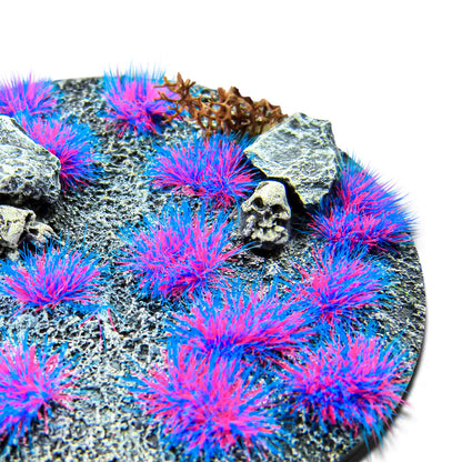Martian Fluor Tufts 6mm Sulley Purple-Blue Green Stuff World - zbliżenie na okrągłą podstawkę sci-fi z fioletowo-niebieskimi fluorescencyjnymi kępkami trawy, czaszką i kamieniami

