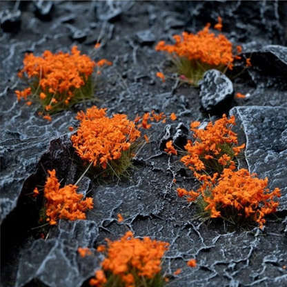 Orange Flowers 6mm Wild Gamers Grass - diorama z ciemnymi łupkowymi skałami pokryta intensywnie pomarańczowymi kępkami kwiatowymi tworzącymi ognisty kontrast na czarnym tle
