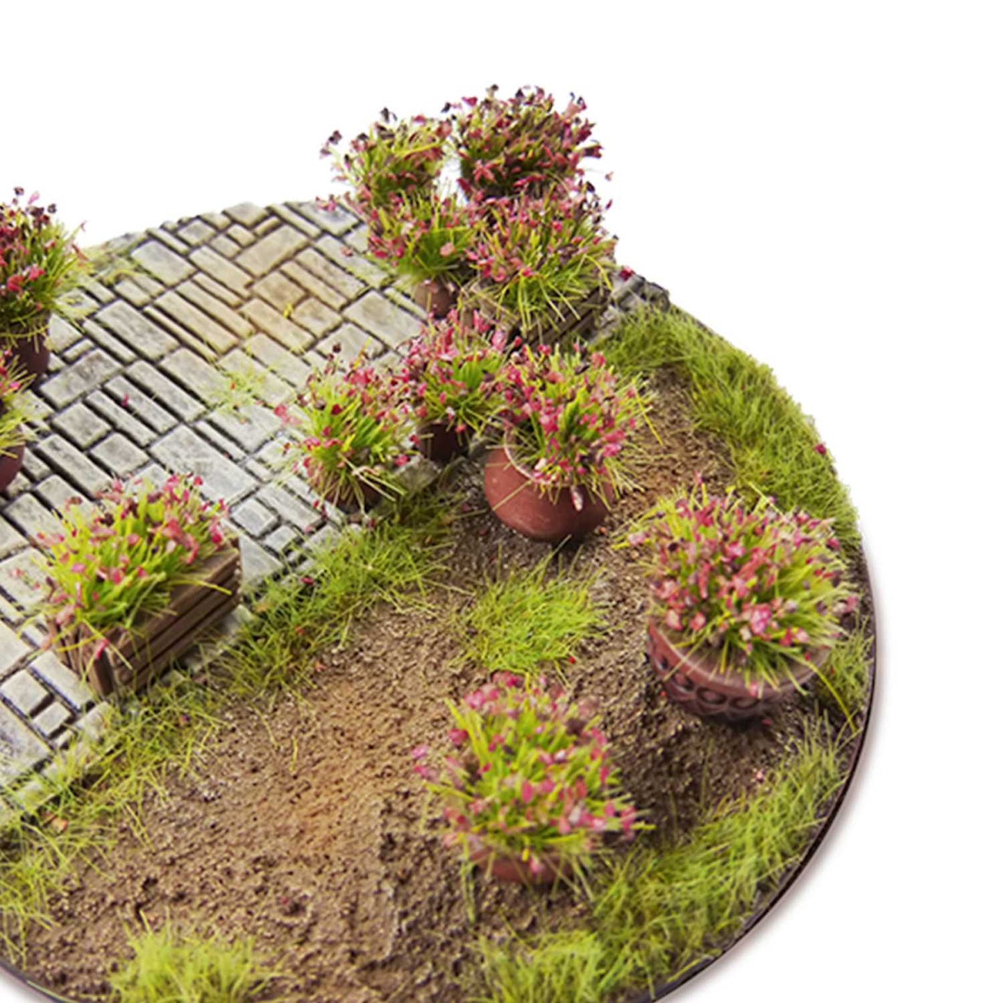 Shrub Tufts 6mm Light Purple Green Stuff World - diorama z brukowaną ścieżką i krzewinkami z jasnofioletowymi kwiatami na okrągłej podstawce
