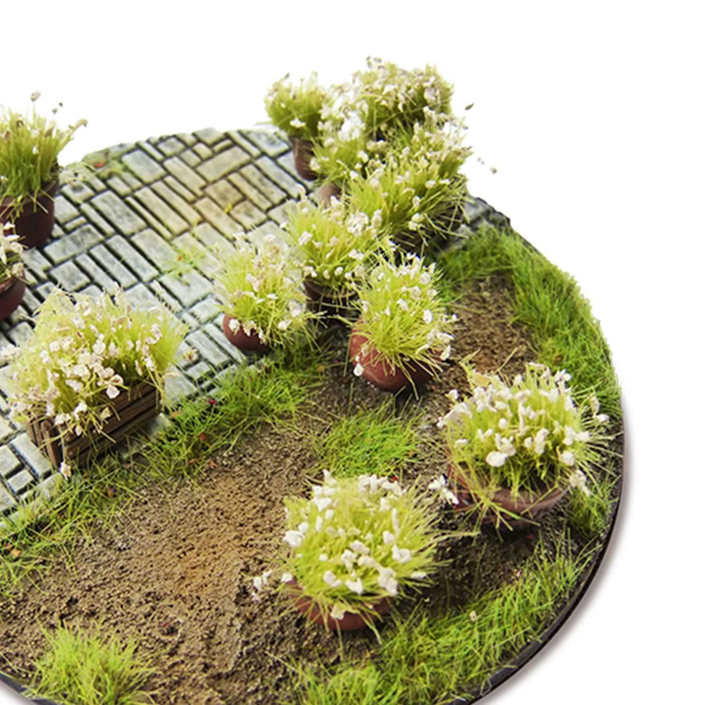 Shrub Tufts 6mm White Green Stuff World - diorama z brukowaną ścieżką i krzewinkami z białymi kwiatami na okrągłej podstawce
