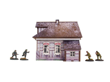 Ostfront Village Whitewashed Dacha – widok z przodu na dwa okna z ozdobnymi framugami i przybudówkę, żołnierze po bokach, 28mm Bolt Action

