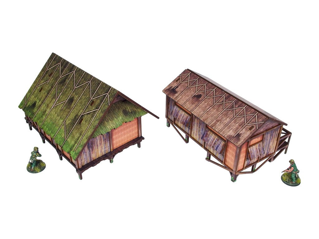 WW2 Pacific Jungle Huts (2) PREPAINTED – dwie zmontowane chaty dżunglowe na palach, widok z góry pod kątem: zielona strzecha (lewa) i brązowa strzecha (prawa) z werandą, figurki żołnierzy 28mm Bolt Action, białe tło

