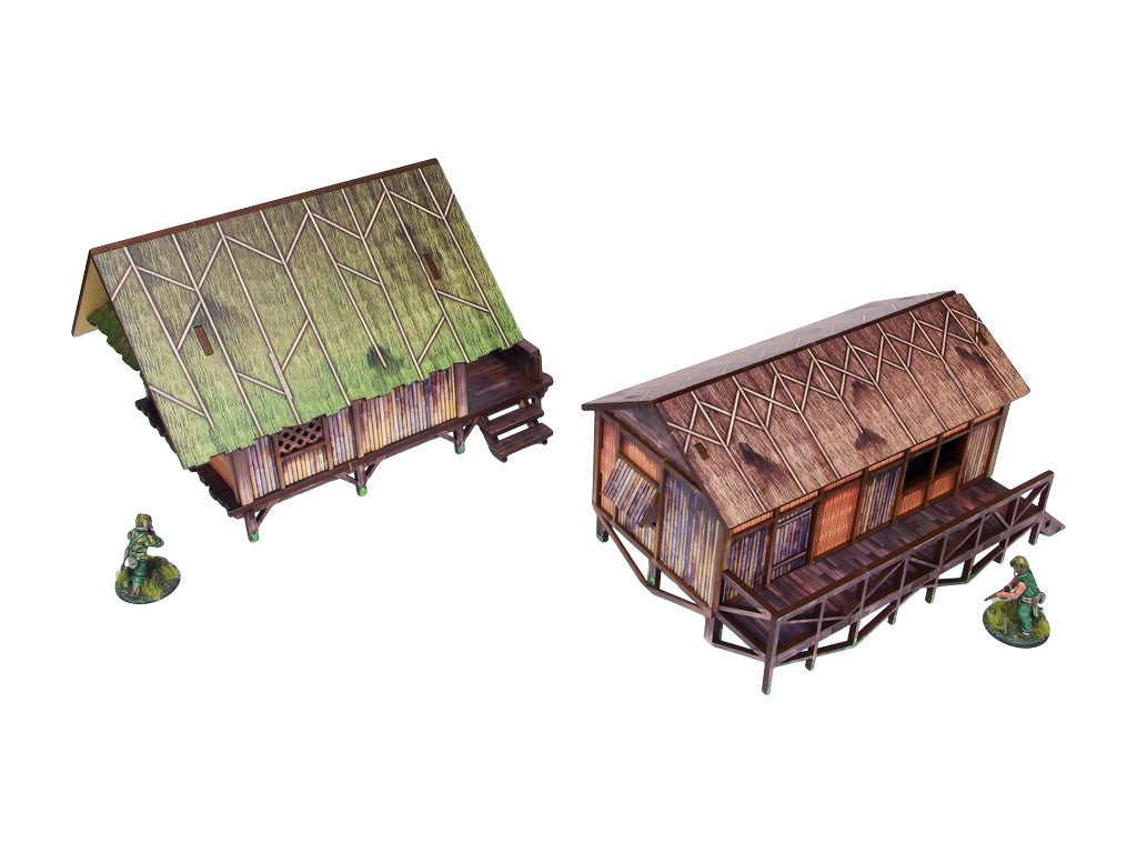 WW2 Pacific Jungle Huts (2) PREPAINTED – dwie zmontowane chaty dżunglowe na palach z UV-drukowanym malowaniem: zielona strzecha (lewa) i brązowa strzecha (prawa), obok figurki żołnierzy 28mm Bolt Action, białe tło
