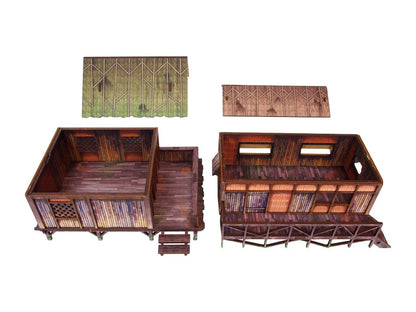 WW2 Pacific Jungle Huts (2) PREPAINTED – dwie chaty dżunglowe z zdjętymi dachami, widok z góry na wnętrza z UV-drukowanymi detalami podłogi i ścian, białe tło
