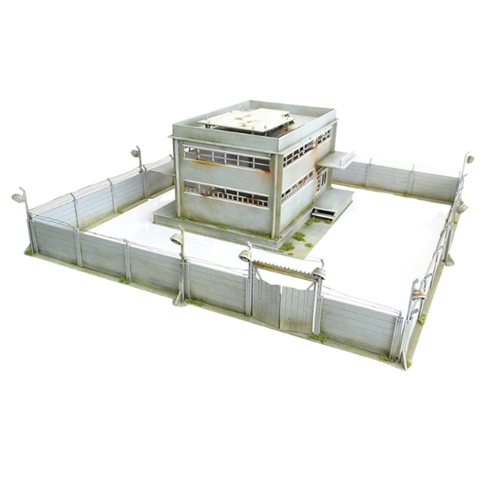 Secure Compound Scenery Set Q023 – widok izometryczny na kompletny zestaw: 2-piętrowy magazyn z lądowiskiem dla helikopterów otoczony murami z reflektorami i bramą wjazdową, surowe MDF, 28mm Sarissa Precision
